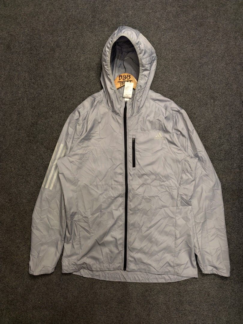 Adidas Windbreaker Running Jacket (Category: Coats, Jackets and Outerwear) located in Cordova. Submitted by bsb.streetluxvintage.clothing (Listing ID 1459788752, Image 1). Description: - Lightweight grey Adidas jacket - Classic 3 stripes on sleeve - Features a zip pocket - Adjustable drawstring at the hem - Ideal for running and outdoor activities - Made in China.