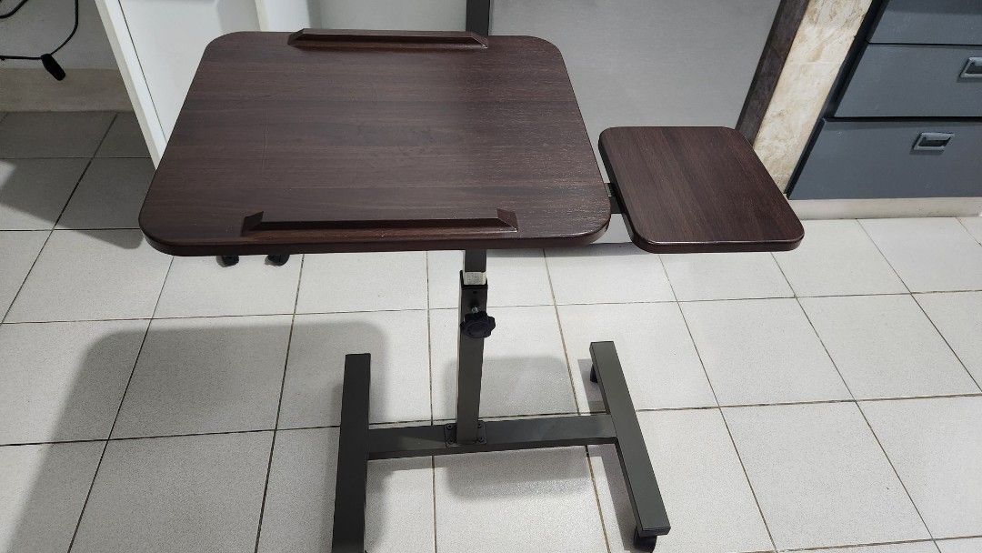 Adjustable Height Laptop Table with Wheels (Category: Tables & Sets) located in Manila. Submitted by happybear_77e59e777 (Listing ID 1459843010, Image 2). Description: - Adjustable height laptop table - Easy height adjustment with side knob - Built-in wheels for convenient mobility - Dark wood tabletop - Approximate dimensions: 60cm x 40cm - Ideal for working comfortably on your bed or sofa.