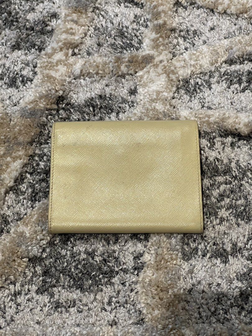 AUTHENTIC Prada Saffiano Bifold Wallet – Cream/Beige (Category: Luxury Bags & Wallets) located in Cavite. Submitted by charmscloset888 (Listing ID 1459725577, Image 2). Description: Prada Saffiano Bifold Wallet – Cream/Beige CONDITION: WELL USED / RESTORED Please see all photos carefully. This wallet has been recolored/restored. There are visible signs of use, including wear/cracking along the edges and corners. Interior is still clean and usable