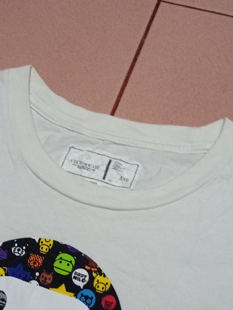 BAPE x CHOCOOLATE Baby Milo Graphic Tee (Category: Shirts) located in Labo. Submitted by hikari_archive (Listing ID 1459807366, Image 3). Description: BAPE x CHOCOOLATE Baby Milo Graphic Tee (xxs on tag) dimes: inches width: 16.12 length: 23.6 - verygood condition - have sign of usage - cut wash tag, need wash.