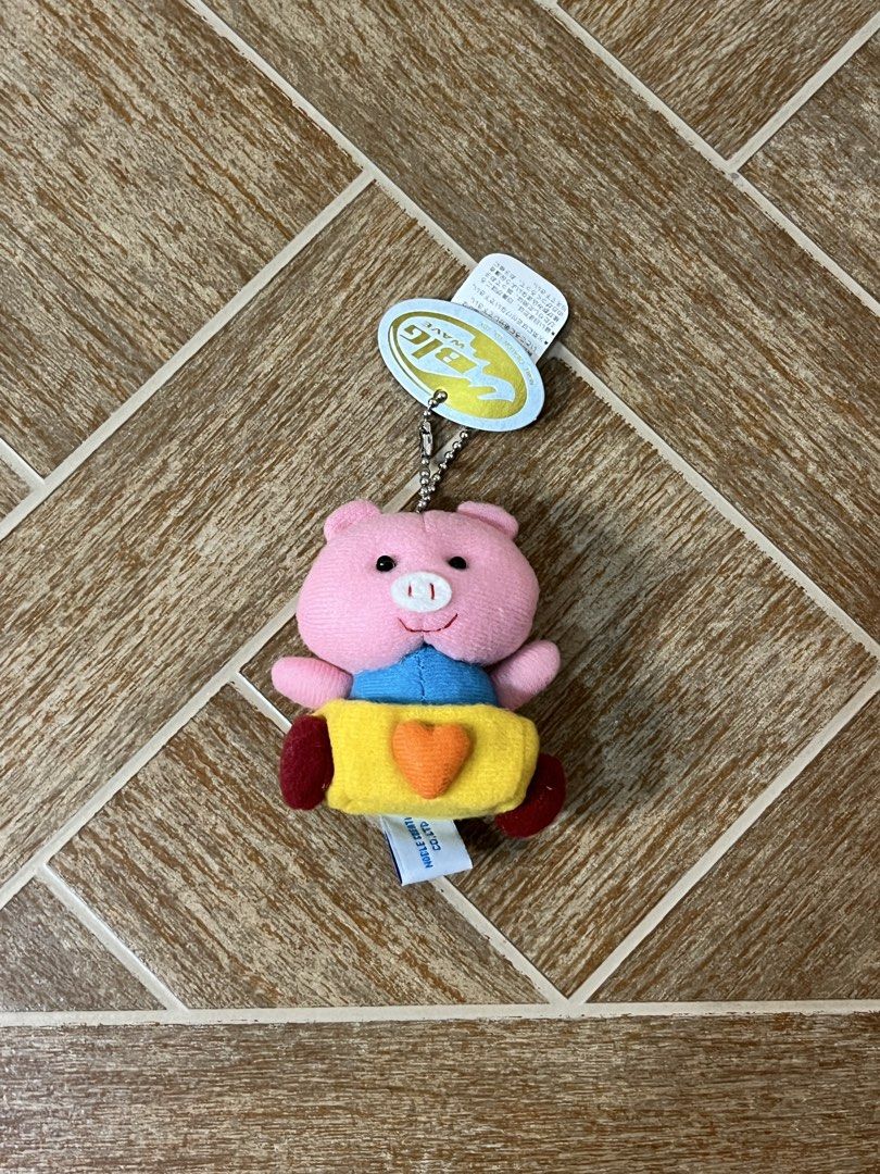 BIG WAVE Pig Plush Keychain with Tag (Category: Plushies & Soft Toys) located in Gapan. Submitted by lunashop14 (Listing ID 1459753359, Image 1). Description: - Adorable pink pig plush toy - Features a cute yellow outfit and red feet - Detailed with a blue shirt and an orange heart - Includes original tag - Comes with a silver ball chain for easy attachment - Ideal for decorating bags or as a keychain - Manufactured by Noble Creation Co., Ltd..