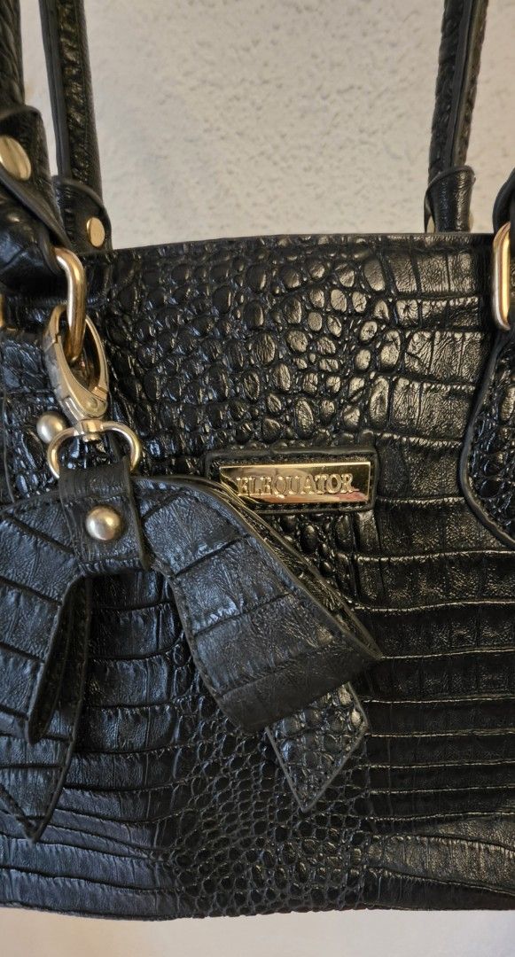 Black Crocodile Embossed Handbag with Bow Detail (Category: Luxury Bags & Wallets) located in Manila. Submitted by amc88 (Listing ID 1459698020, Image 3). Description: - Stylish black handbag with a luxurious crocodile embossed texture. - Adorable bow detail on the front for a feminine touch. - Elegant gold hardware accents throughout. - Convenient zippered pocket on the back for quick access. - Comfortable top handles for easy carrying. - Spacio