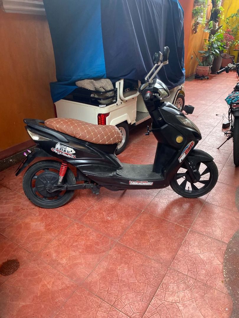 Black Electric Scooter with Charger (Category: Skates, Rollerblades & Scooters) located in Bacoor. Submitted by jmb.mktg0831 (Listing ID 1459735163, Image 1). Description: - Sleek black electric scooter - Includes charger - Comfortable brown patterned seat - Unique stickers on the body - Ready to ride, perfect for getting around town - Negotiable.