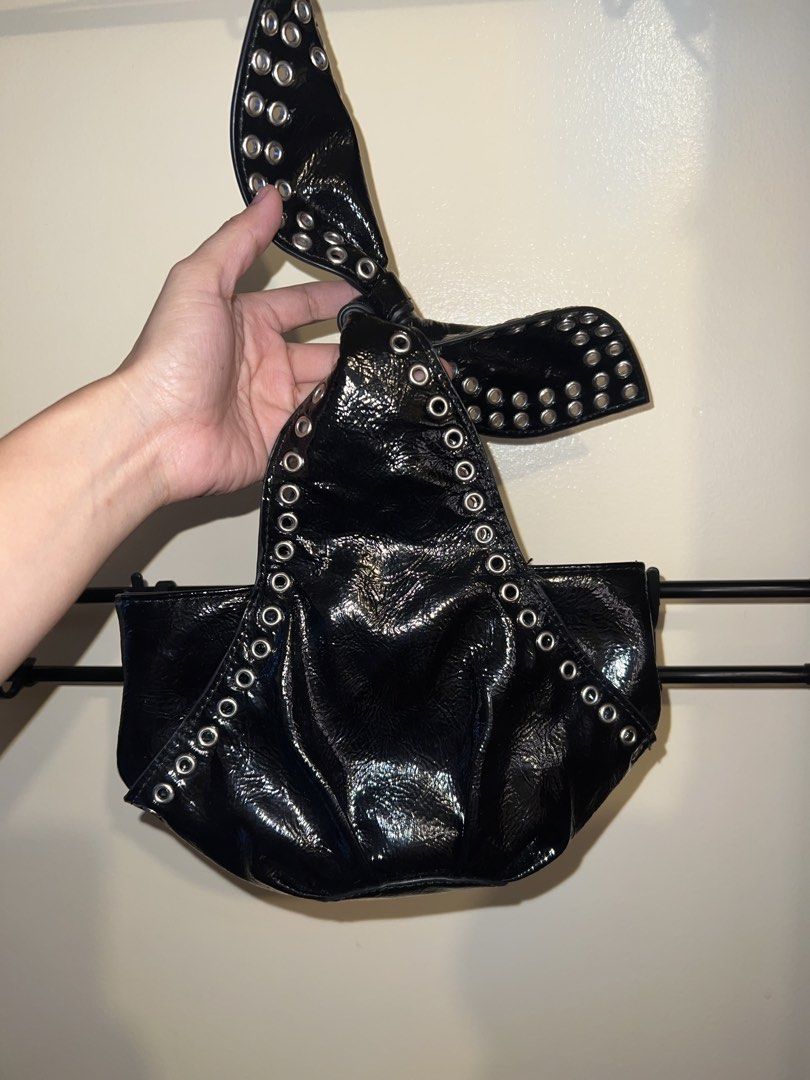 Black Patent Studded Knot/Dumpling Handbag (Category: Tote Bags) located in Mandaluyong City. Submitted by chelseayb47224 (Listing ID 1459821109, Image 1). Description: - Used once - Unique knotted dumpling design - Silver studs all around - Zipper closure inside - Small size, perfect for essentials - Adds an edgy vibe to any outfit - Check photos for details.
