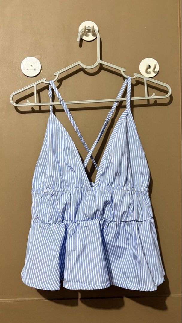 Blue and White Striped Peplum Cami Top (Category: Sleeveless) located in Caloocan City. Submitted by zandrarubio (Listing ID 1459724997, Image 2). Description: - Cute blue and white striped cami top - Flattering V-neckline - Stylish criss-cross straps at the back - Elasticated waist for a comfortable fit - Peplum hem for a feminine touch - Ideal for casual outings or beach days - Versatile: pair with shorts or a skirt.