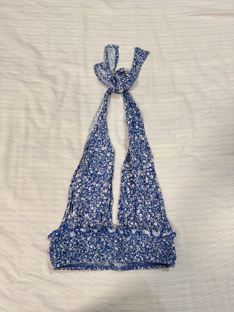 Blue Floral Halter Neck Crop Top (Category: Sleeveless) located in Quezon City. Submitted by shop.lize (Listing ID 1459856311, Image 1). Description: - Blue halter neck crop top - White floral print - Smocked back for a comfy fit - Ties at the neck - Ruffled hem detail - Ideal for summer or beach trips.