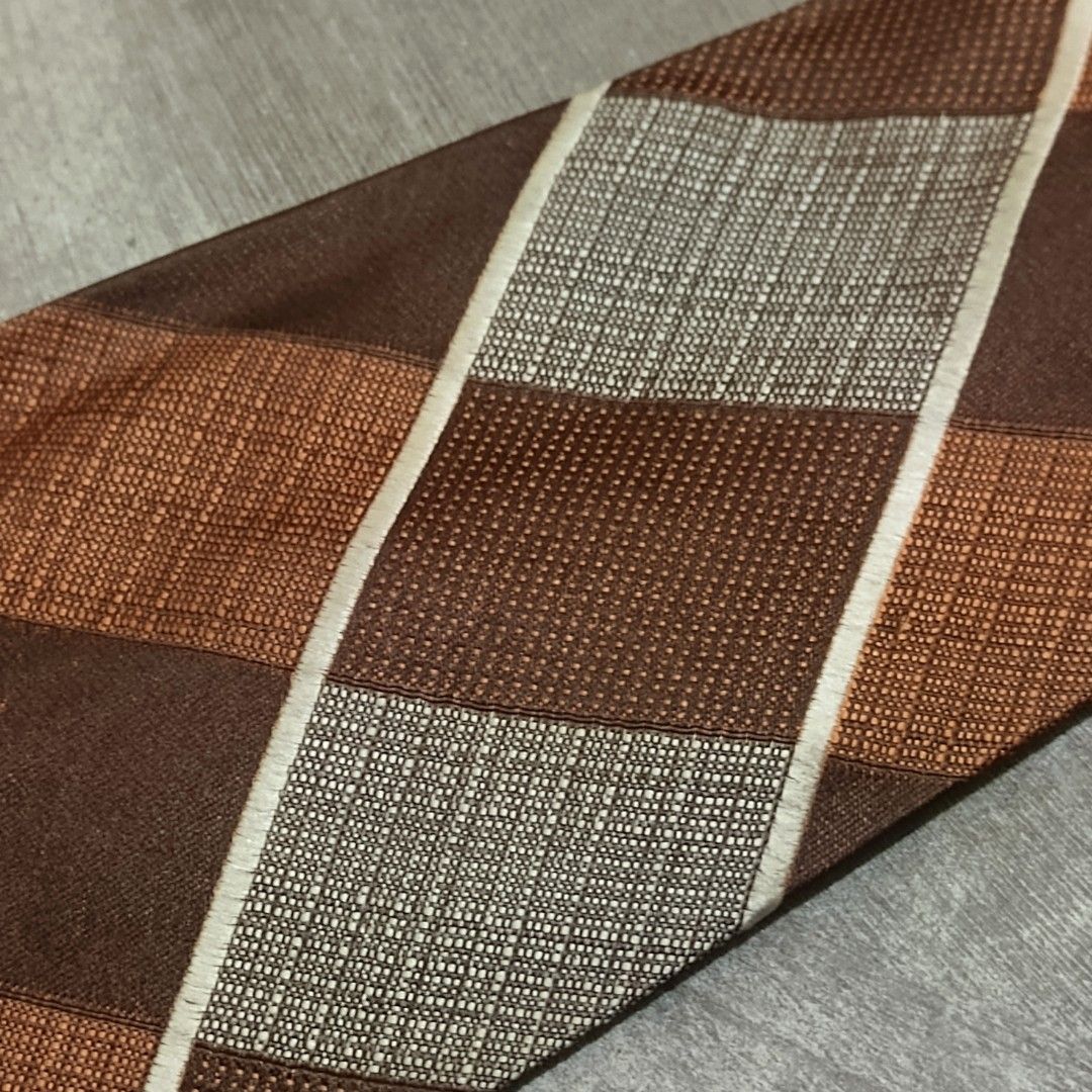 Blue mountain necktie (Category: Ties) located in Abucay. Submitted by gibzzz123 (Listing ID 1459795801, Image 3). Description: brown and copper patterned men's necktie featuring a diagonal plaid or argyle-style checkered design with white accent stripes . All items are ON HAND and ready to be shipped/picked up. • Items are preloved/ukay, so please expect minimal signs of usage unless stated otherwise. • No major issues — good condition unless ot