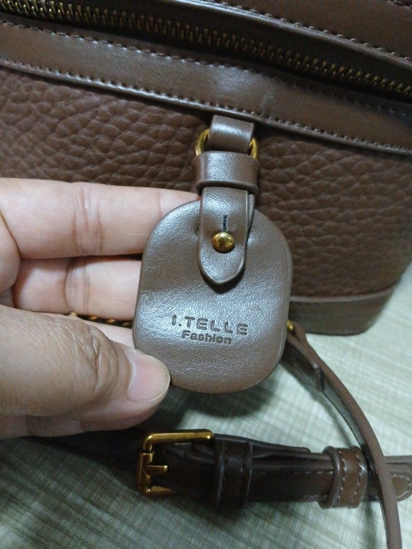 Brown Leather Vanity Bag with Gold Chain Strap (Category: Luxury Bags & Wallets) located in Taguig. Submitted by jegadablo (Listing ID 1459812865, Image 2). Description: - Stylish brown leather vanity bag - Textured finish for a premium look - Elegant gold chain strap and top handle - Secure zipper closure - Cute buckle detail on the front flap - Compact size, ideal for carrying essentials.