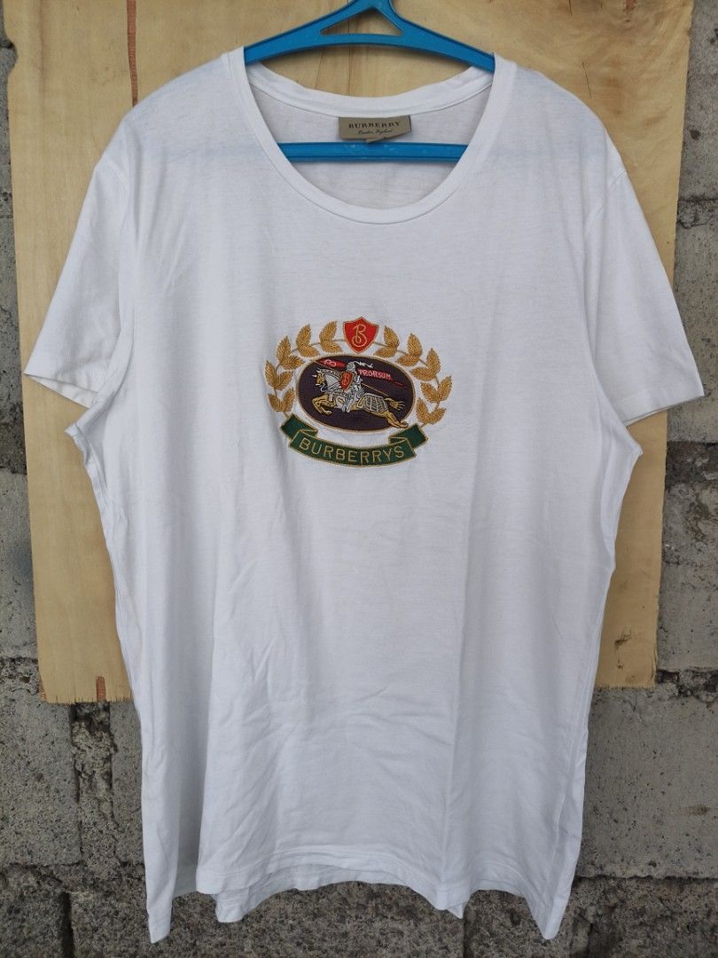 Burberry white tee (Category: Tshirts & Polo Shirts ) located in La Carlota. Submitted by a_leam_art (Listing ID 1459760652, Image 1). Description: Embroidered logo 📍Dimes: W21 x L28 (L on tag) 📍Condition: Excellent (as new) 📍Issue: --- 📍Color rate: 10/10.