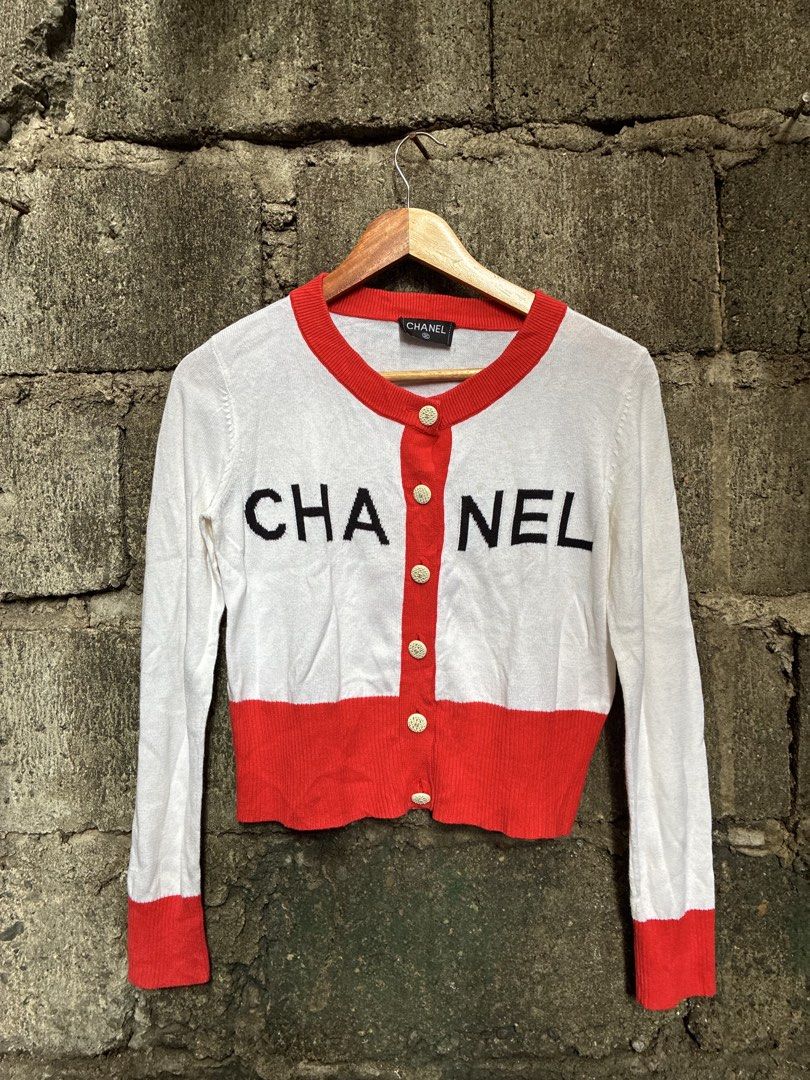 Chanel White Red Logo Button Cardigan (Category: Luxury Apparel) located in Manila. Submitted by assortedgoodsv3 (Listing ID 1459720069, Image 1). Description: - Classic Chanel cardigan - Color: White with red trim and cuffs - Features Chanel logo on buttons - Bold 'CHANEL' lettering across the front - Made in France - Size: 34 - Perfect for fashion enthusiasts.
