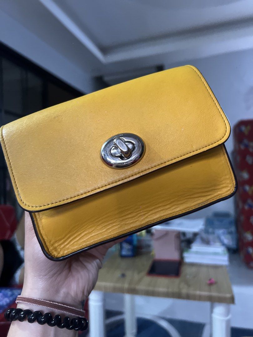 Coach Bowery Chain (Category: Wallets & Card holders) located in Bulacan. Submitted by heyitsmarf (Listing ID 1459862216, Image 1). Description: - Yellow leather wallet - Silver turnlock closure - Signs of wear on bottom edge - Interior not pictured - Ideal for organizing cards and cash.