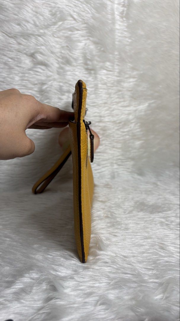 COACH LARGE CORNER ZIP WRISTLET ✨ (Category: Purses & Pouches) located in Manila. Submitted by vintage_og_bagash (Listing ID 1459833648, Image 2). Description: COACH LARGE CORNER ZIP WRISTLET ✨ DETAILS • Brand: Coach • Style: Large Corner Zip Wristlet • Color: Mustard Yellow • Zip-top closure • Spacious interior for cards, cash, phone & small essentials • Wrist strap for easy carry • Comes with a floral charm/accessory as shown 🌸 CONDITION Good 