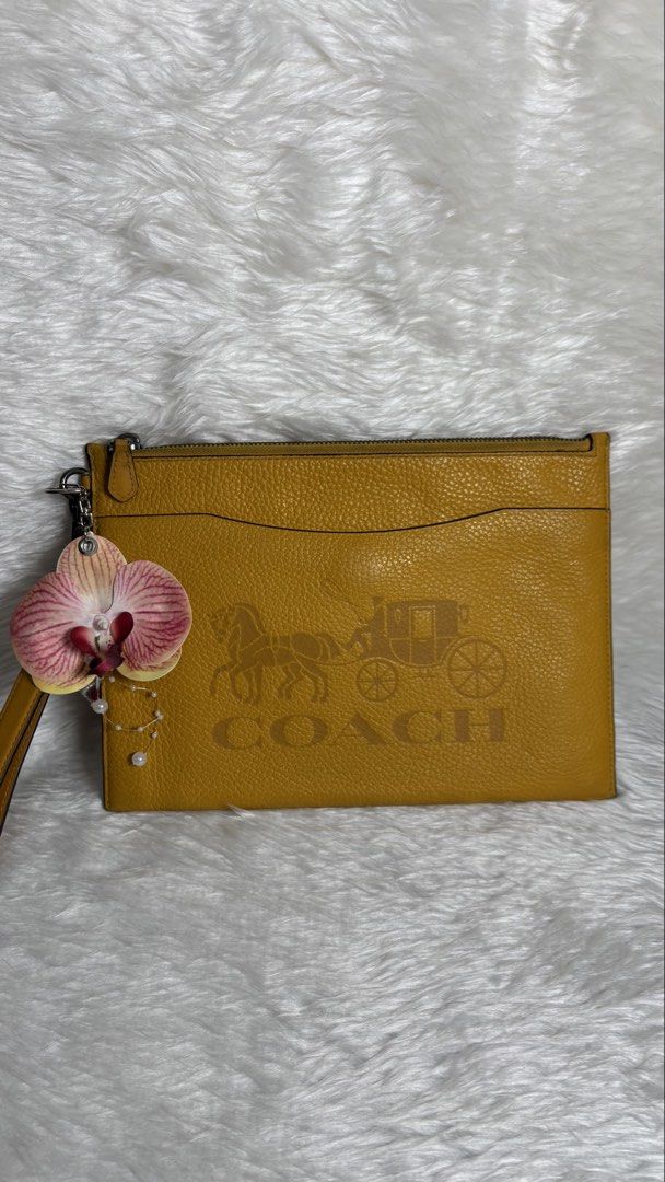 COACH LARGE CORNER ZIP WRISTLET ✨ (Category: Purses & Pouches) located in Manila. Submitted by vintage_og_bagash (Listing ID 1459833648, Image 1). Description: COACH LARGE CORNER ZIP WRISTLET ✨ DETAILS • Brand: Coach • Style: Large Corner Zip Wristlet • Color: Mustard Yellow • Zip-top closure • Spacious interior for cards, cash, phone & small essentials • Wrist strap for easy carry • Comes with a floral charm/accessory as shown 🌸 CONDITION Good 
