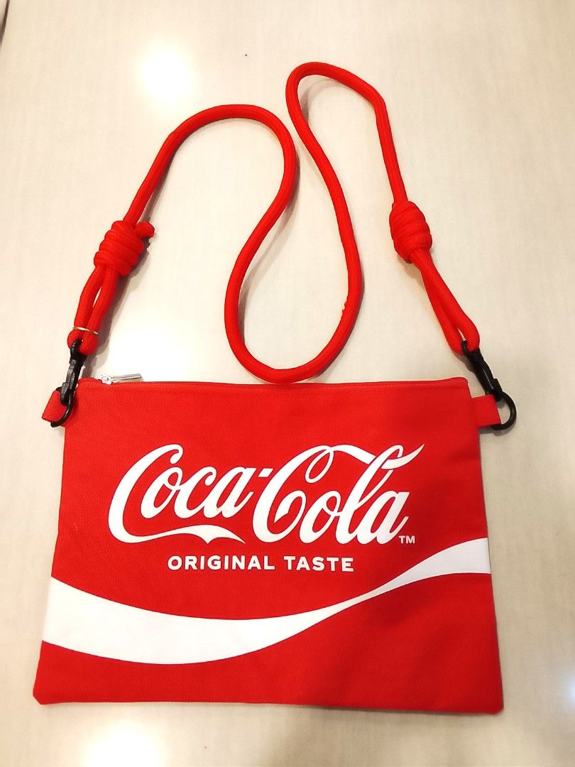 Coca-Cola Red Canvas Sling Pouch Bag (Category: Purses & Pouches) located in Manila. Submitted by newage.vintage (Listing ID 1459804748, Image 1). Description: - Red Coca-Cola pouch bag - Adjustable red rope strap - Zipper closure - Ideal for carrying essentials - Iconic Coca-Cola logo on the front - Simple back design with two white contour bottles - Great for casual outings.