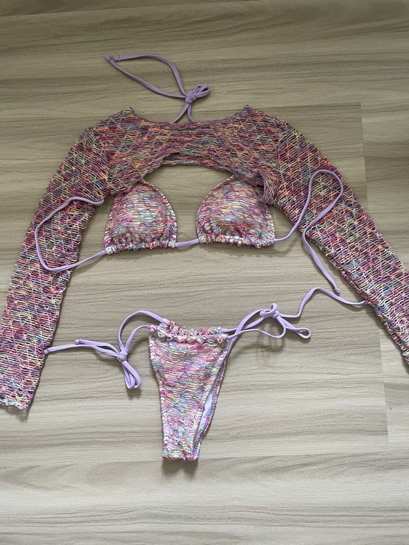 Crochet Bikini Set with Cover-up Top (Category: Bikinis & Swimsuits) located in Manila. Submitted by possiblymaybe.717 (Listing ID 1459781053, Image 1). Description: - Three-piece crochet bikini set - Includes bikini top, bikini bottoms, and long-sleeve cover-up - Features a colorful, rainbow-like pattern - Accented with purple ties - Cover-up is cropped with an open front - Ideal for beach or pool outings.