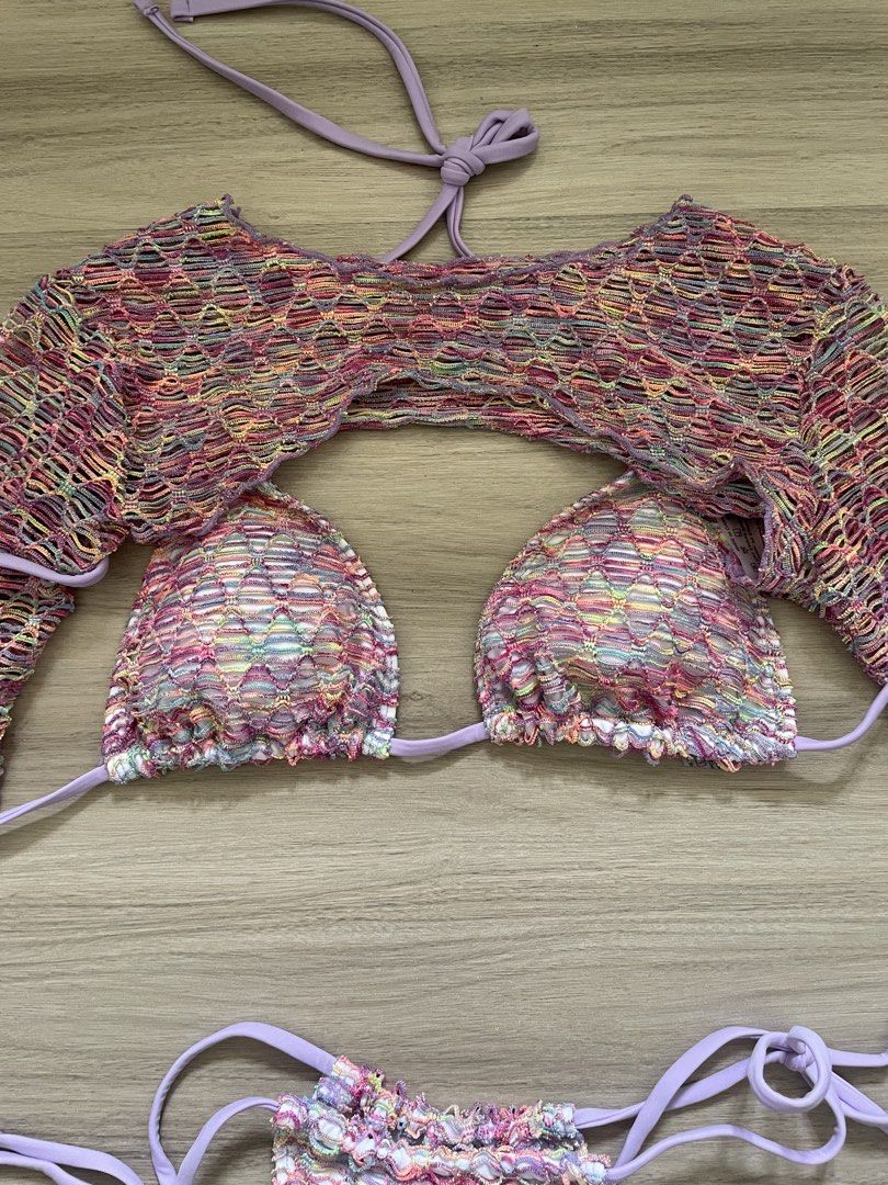 Crochet Bikini Set with Cover-up Top (Category: Bikinis & Swimsuits) located in Manila. Submitted by possiblymaybe.717 (Listing ID 1459781053, Image 2). Description: - Three-piece crochet bikini set - Includes bikini top, bikini bottoms, and long-sleeve cover-up - Features a colorful, rainbow-like pattern - Accented with purple ties - Cover-up is cropped with an open front - Ideal for beach or pool outings.