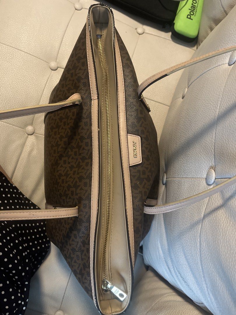 DKNY Monogram Tote Bag (Category: Luxury Bags & Wallets) located in Pasig City. Submitted by jnzmrq1003 (Listing ID 1459773415, Image 3). Description: - Brown DKNY tote bag - Signature monogram print - Tan trim and straps - Zipper closure for security - Light beige interior lining with DKNY logo pattern - Ample space for everyday essentials - Ideal for daily use.