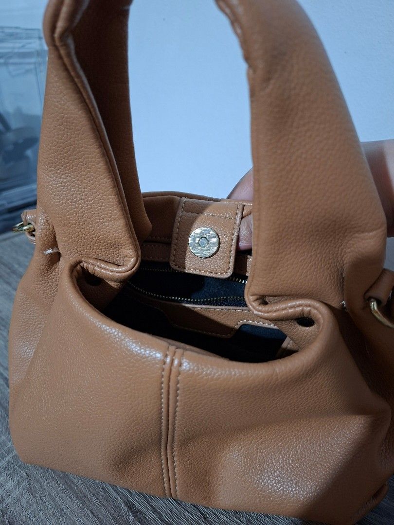 Faux Leather Handbag (Category: Shoulder Bags) located in Angeles City. Submitted by closetbydey (Listing ID 1459799762, Image 3). Description: Cute brown handbag. Made from faux leather material. Has a magnetic snap closure and an inner zip pocket. Comes with a detachable strap. .
