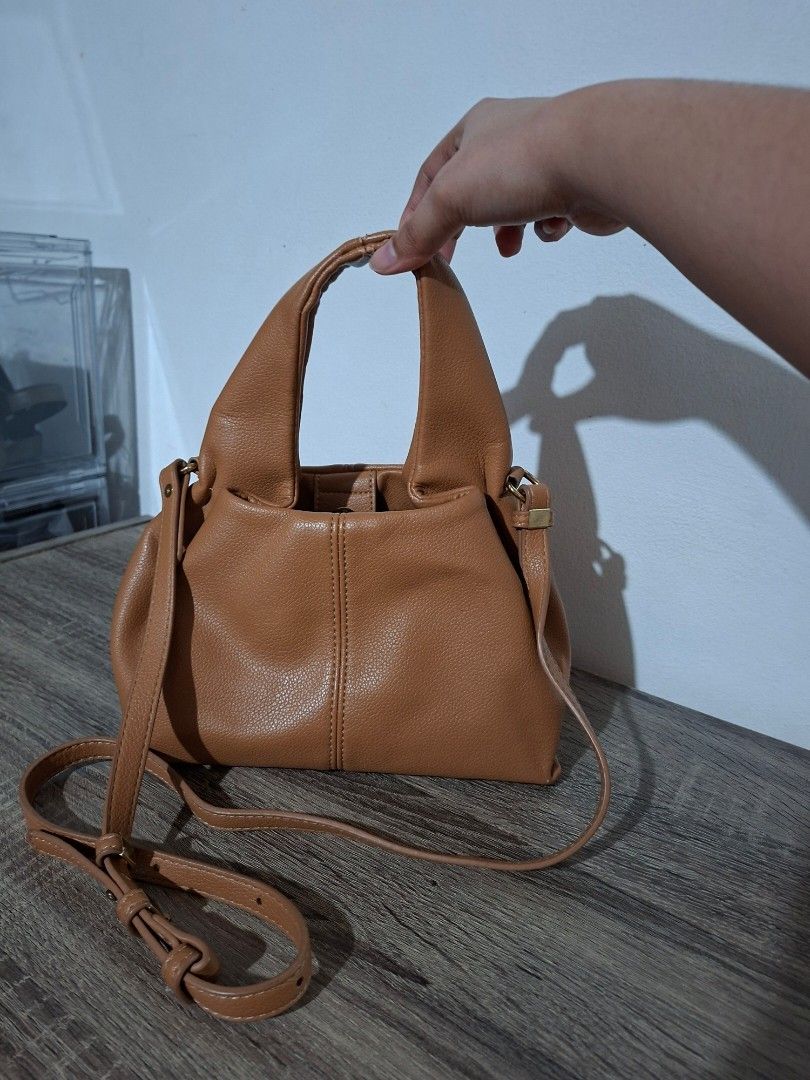 Faux Leather Handbag (Category: Shoulder Bags) located in Angeles City. Submitted by closetbydey (Listing ID 1459799762, Image 2). Description: Cute brown handbag. Made from faux leather material. Has a magnetic snap closure and an inner zip pocket. Comes with a detachable strap. .