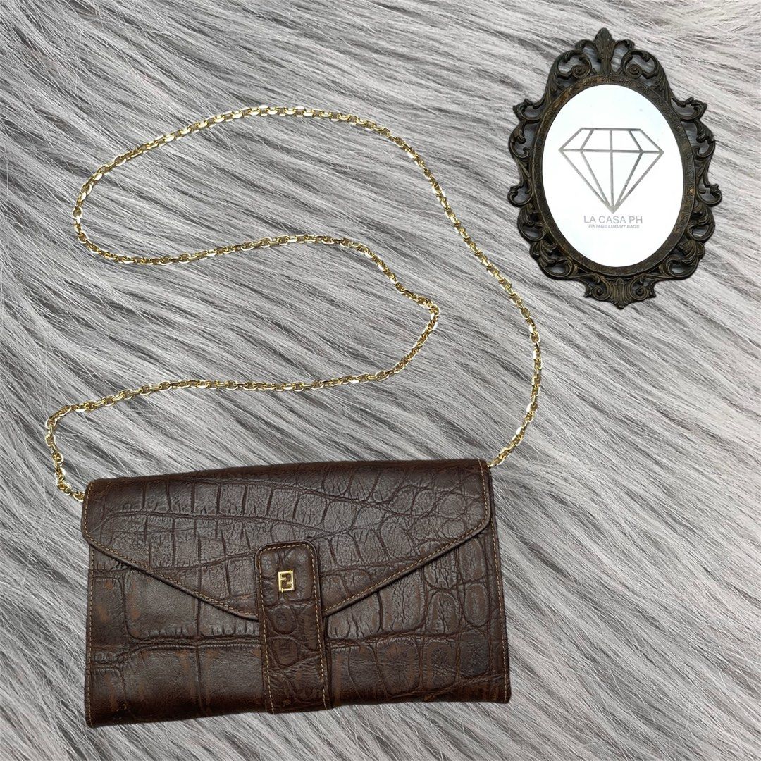 FENDI Croc Embossed Flap Wallet Clutch (Category: Luxury Bags & Wallets) located in Cagayan de Oro. Submitted by lacasaph (Listing ID 1459847636, Image 1). Description: FENDI Croc Embossed Flap Wallet Clutch • Rank AB • Rare piece! • 8 x 4.5 inches • Can fit big phones • No holes, tears on body • Can also be worn as a WOC • Free brandnew inserts and chain 🏷️ ₱2,500 **Product color may slightly vary due to photographic lighting sources or your sc