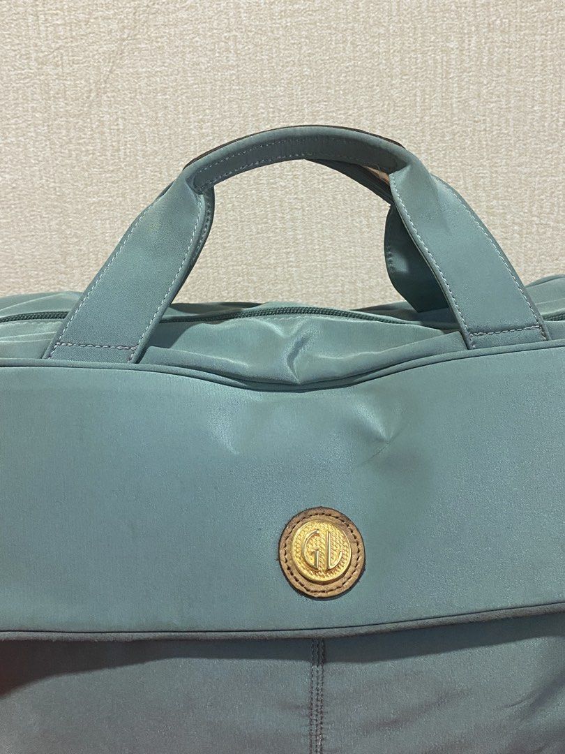 GD Daffle Bag Light Blue Nylon Leather Trim (Category: Tote Bags) located in Manila. Submitted by cdb_22 (Listing ID 1459818399, Image 3). Description: - Chic light blue tote bag with elegant leather trim. - Secure main zip compartment and a convenient back zip pocket. - Features a stylish gold-tone logo emblem on the front flap. - Comfortable leather handles for easy carrying. - Includes a detachable strap for versatile wear. - Ideal for everyda
