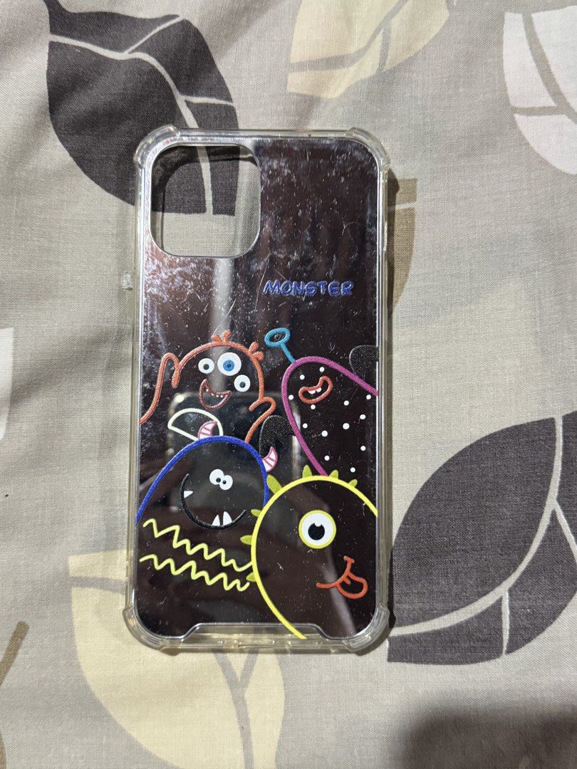 Glass Iph 12 Pro Max Case (Category: Cases & Sleeves) located in Obando. Submitted by pepperooshop (Listing ID 1459714236, Image 1). Description: - Glass case for iPhone 12 Pro Max - Features a fun 'MONSTER' design with colorful cartoon monsters - Shiny, reflective back with clear sides - Offers protection and adds a unique style to your phone - Designed for iPhone 12 Pro Max - Iph 12 pro max -rfs:decluttering.