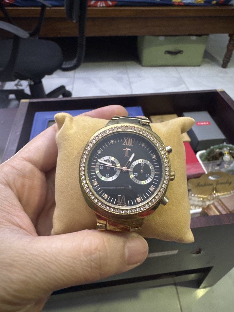 Gold Chronograph Watch with Diamond Bezel (Category: Luxury Watches) located in Valenzuela. Submitted by arizanatividad (Listing ID 1459807117, Image 1). Description: - Stunning gold-tone watch - Classic black dial - Luxurious diamond-encrusted bezel - Functional chronograph with two sub-dials - Comfortable bracelet strap with fold-over clasp - Roman numerals at 12 and 6 o'clock - Overall stylish and eye-catching design.