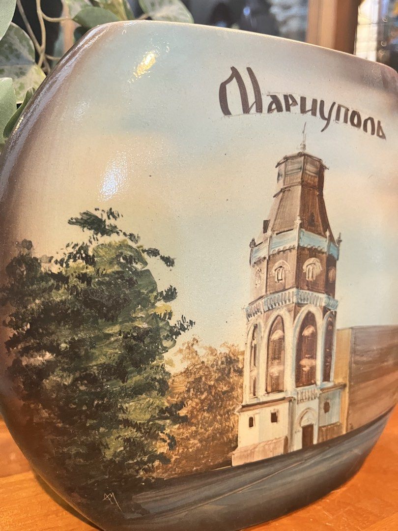 Hand Painted Mariupol Water Tower Pillow Shape Ceramic Vase (Category: Vases & Decorative Bowls) located in Calamba. Submitted by chebvintagedepot (Listing ID 1459762787, Image 2). Description: [B06-01] This ceramic vase has a distinctive flattened oval form with hand-painted architectural scenes. One side depicts the historic Old Water Tower in Mariupol, Ukraine, with the city name “Мариуполь” written above in Cyrillic script. The other side sho