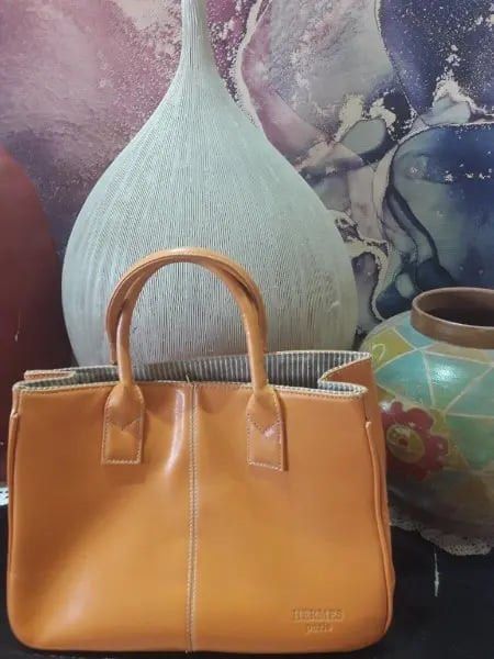 Hermes Paris Leather Tote Bag (Category: Luxury Bags & Wallets) located in Manila. Submitted by justdanzzz_ (Listing ID 1459819668, Image 1). Description: - Hermes Paris orange leather tote bag - AUTHENTICITY is not guaranteed. Check Zweely website for the product—it says "sac Hermes paris original". Buy at your own risk. - Classic design with elegant braided handles - Interior features a stylish striped lining - Simple, chic, and versatile for e
