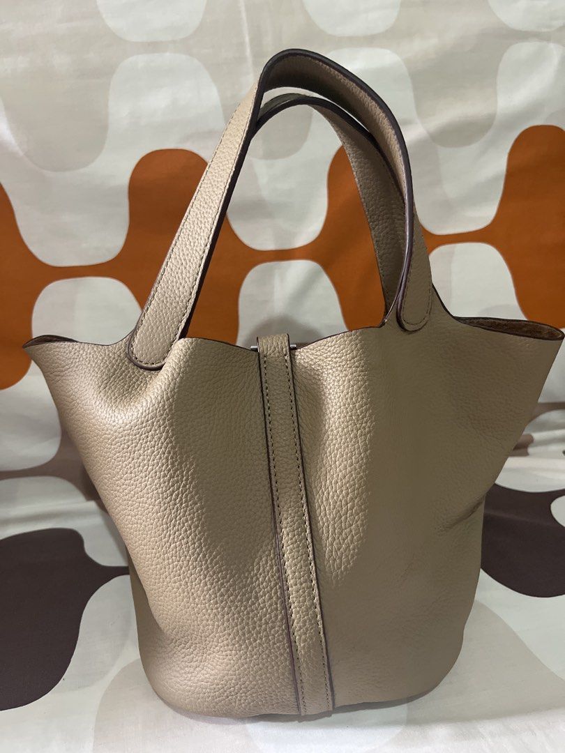 Taupe Leather Picotin Bucket Bag 22cm (Category: Luxury Bags & Wallets) located in Las Pinas. Submitted by erenrosc (Listing ID 1459737319, Image 3). Description: - Classic bucket bag style - Made from textured leather - Includes lock and key - Four protective studs on the base - Spacious interior - Comfortable top handles - Versatile for daily use.