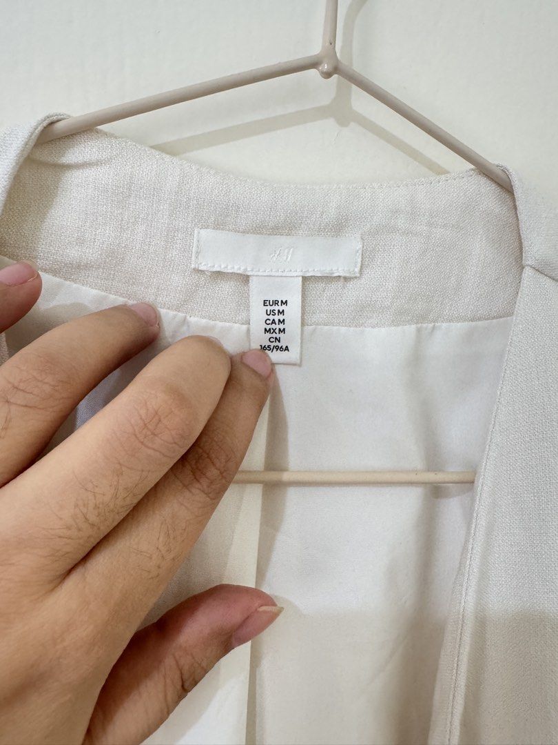 H&M Sleeveless Vest with Belt (Category: Sleeveless) located in Mandaluyong City. Submitted by trinket.ph (Listing ID 1459734708, Image 2). Description: - Cream sleeveless vest from H&M - Size: Medium (M) - Comes with a black tie belt - Can be worn open or tied - Perfect for layering over any outfit.