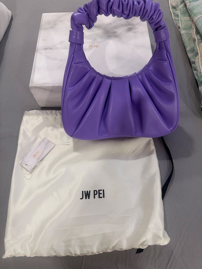 JW Pei Purple Ruched Shoulder Bag (Category: Shoulder Bags) located in Taguig. Submitted by nala123 (Listing ID 1459854428, Image 1). Description: - Brand: JW Pei - Color: Purple - Style: Shoulder bag - Features: Ruched design, single top handle, interior pocket - Includes: Dust bag, original box - Perfect for: Adding a vibrant accent to any outfit.
