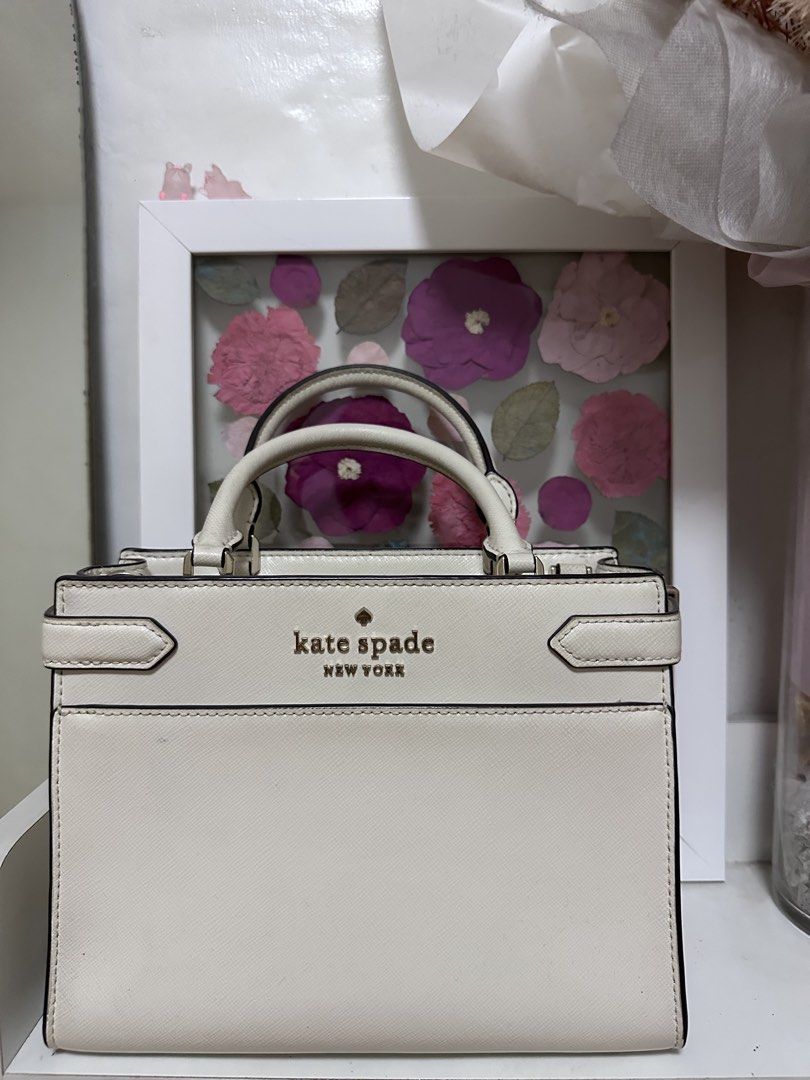 Kate Spade Staci Cameron Medium Satchel Ivory (Category: Luxury Bags & Wallets) located in Pasig City. Submitted by abbygaab (Listing ID 1459821008, Image 2). Description: - Brand: Kate Spade New York - Material: White Leather - Design: Structured top handle bag - Closure: Zip closure - Interior: Zip pocket - Hardware: Gold-tone - Strap: Detachable shoulder strap - Occasion: Great for everyday or special events.