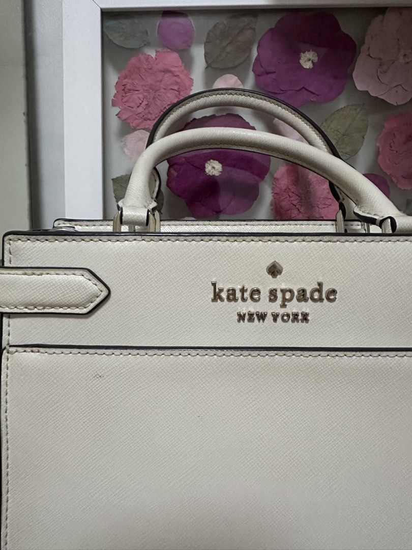 Kate Spade Staci Cameron Medium Satchel Ivory (Category: Luxury Bags & Wallets) located in Pasig City. Submitted by abbygaab (Listing ID 1459821008, Image 3). Description: - Brand: Kate Spade New York - Material: White Leather - Design: Structured top handle bag - Closure: Zip closure - Interior: Zip pocket - Hardware: Gold-tone - Strap: Detachable shoulder strap - Occasion: Great for everyday or special events.