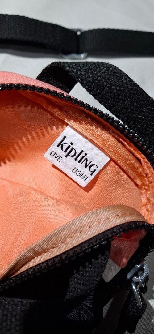Kipling Crossbody Bag Black Coral White (Category: Cross-body Bags) located in Las Pinas. Submitted by therelovedrack (Listing ID 1459871888, Image 3). Description: Cute Kipling crossbody bag in black with coral and white stripes. Features the classic monkey tag, working zippers, and an adjustable strap. Perfect for daily use..