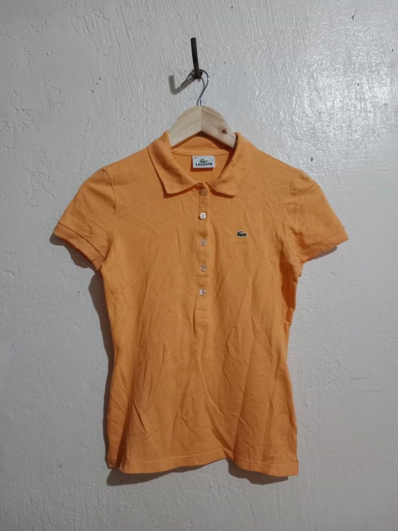 Lacoste Orange Polo Shirt (Category: Blouses) located in Toledo. Submitted by zealzionta54269 (Listing ID 1459743464, Image 1). Description: - Orange Lacoste Polo Shirt - Short sleeves - Collared neckline with button-up front - Iconic embroidered Lacoste crocodile logo on chest - Comfortable cotton blend fabric - Ideal for casual outings and everyday wear -width 16-17 length 22.