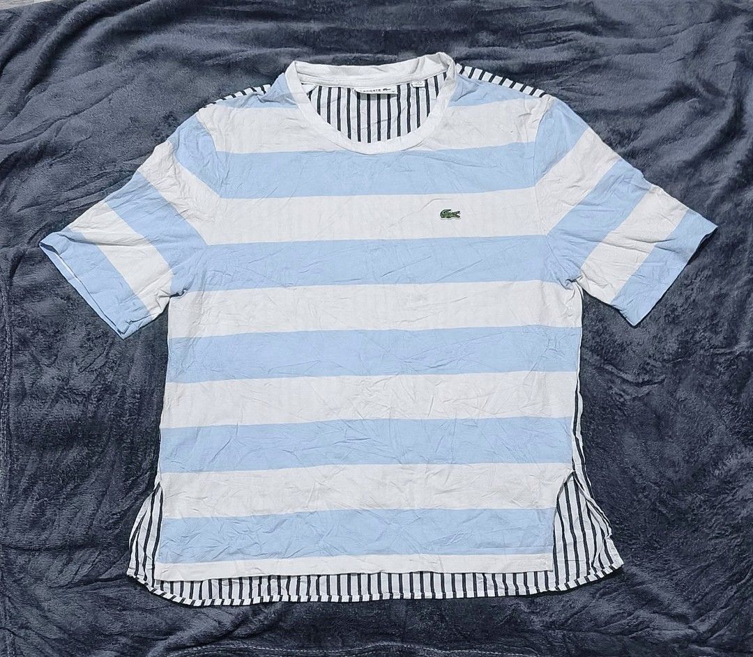 Lacoste Shirt (Category: Luxury Apparel) located in Caloocan City. Submitted by cogeothriftapparel (Listing ID 1459811670, Image 1). Description: For Women Light blue with white stripes Unique Vertical back lines design W 20 L 25 Issue minimal lints Overall Good Condition..
