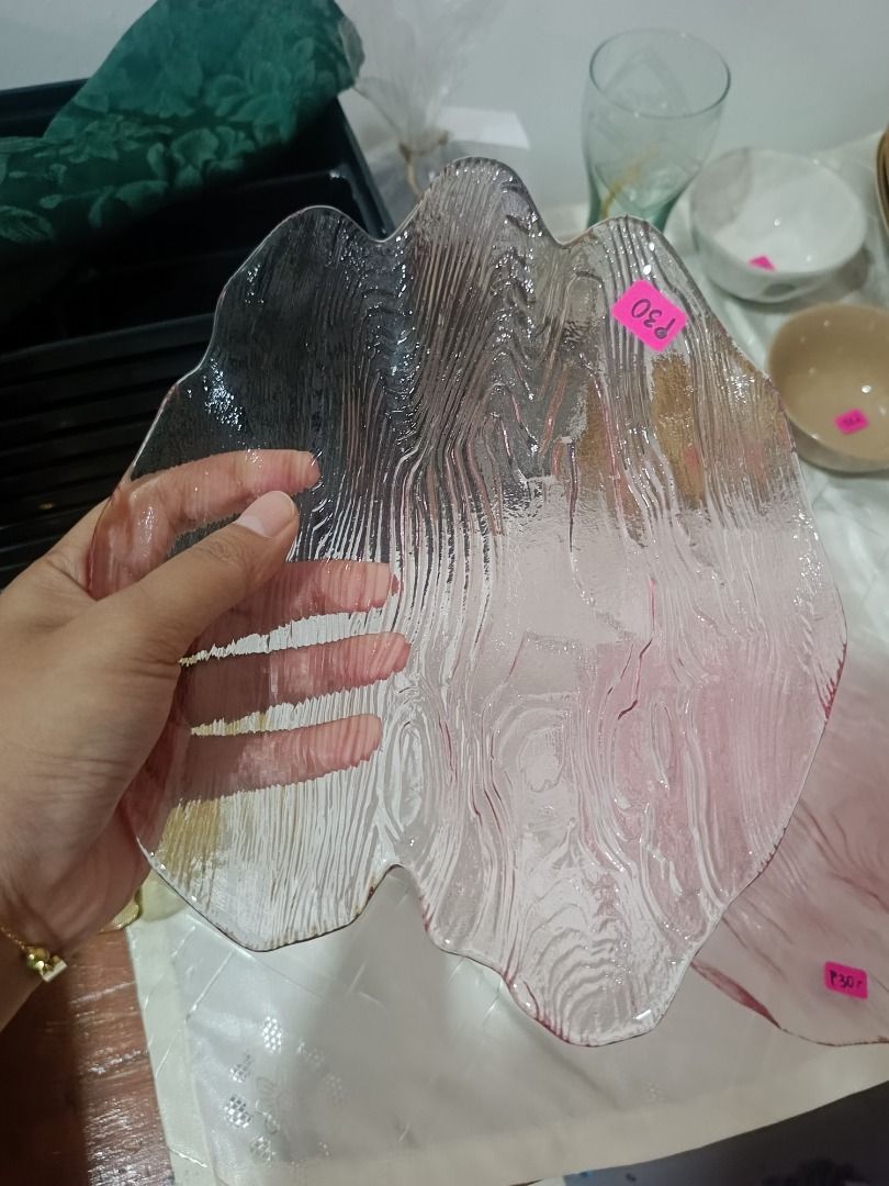 Leaf Shaped Glass Plates (Set of 2) (Category: Dinnerware & Cutlery) located in Quezon City. Submitted by gabade (Listing ID 1459806010, Image 2). Description: - Set of 2 leaf-shaped glass plates - Unique textured surface resembling wood grain - One plate is clear, the other has a subtle pinkish hue - Ideal for serving snacks or as decorative accents - Selling as a set.