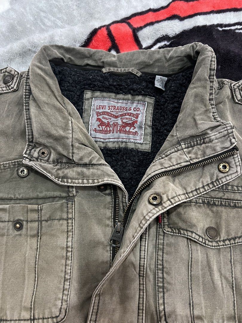 Levi Strauss & Co. Sherpa Lined Utility Jacket (Category: Coats, Jackets and Outerwear) located in Tanza. Submitted by 1954_street (Listing ID 1459769837, Image 3). Description: LEVIS large 25x28 fade part and tattered part 700 - Olive green Levi's utility jacket - Sherpa lined for extra warmth - Zip and button front closure - Two chest pockets and two hand pockets - Size L.