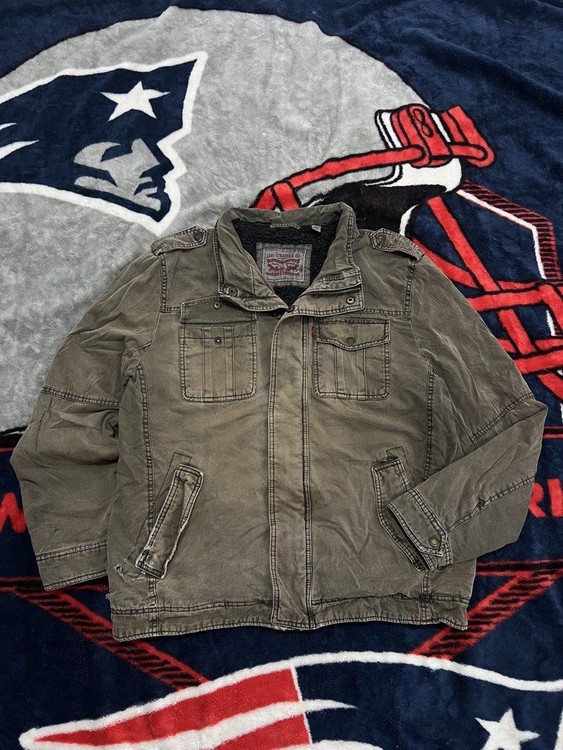 Levi Strauss & Co. Sherpa Lined Utility Jacket (Category: Coats, Jackets and Outerwear) located in Tanza. Submitted by 1954_street (Listing ID 1459769837, Image 1). Description: LEVIS large 25x28 fade part and tattered part 700 - Olive green Levi's utility jacket - Sherpa lined for extra warmth - Zip and button front closure - Two chest pockets and two hand pockets - Size L.