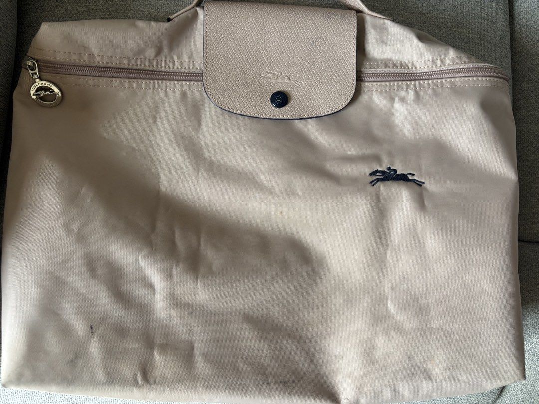 Longchamp Le Pliage Document/Laptop Bag (Category: Luxury Bags & Wallets) located in San Juan City. Submitted by pinkbelle14 (Listing ID 1459693167, Image 2). Description: - Authentic Beige Longchamp document Bag - Durable Nylon Material - Genuine Leather Handles and Trim - Secure Zip Closure with Snap Button Flap - Ideal for Travel or Everyday Use - Requires cleaning.