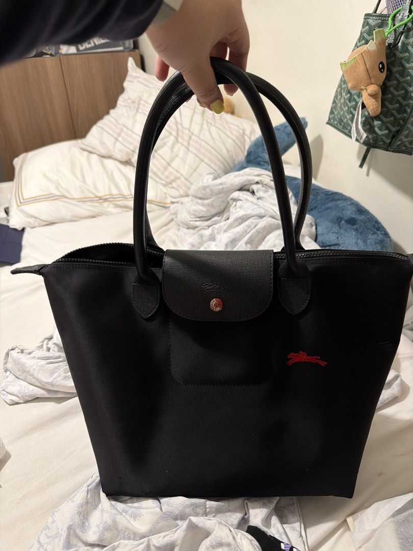 Longchamp Le Pliage Tote Bag Black (Category: Luxury Bags & Wallets) located in Manila. Submitted by shobeshop_ (Listing ID 1459842403, Image 1). Description: - Classic black Longchamp tote bag - Durable nylon body with genuine leather handles and trim - Features the iconic red horse logo - broken zipper closure with a snap-tab flap ( can repair) - Includes an interior pocket for organization - Ideal everyday bag for carrying essentials - please 