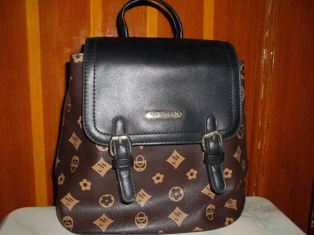 Madleen Brown Monogram Backpack (Category: Backpacks) located in Quezon City. Submitted by rdonelle (Listing ID 1459766635, Image 1). Description: - Brand: Madleen - Color: Brown with black flap - Closure: Buckle closures on front - Pockets: Zip pocket on back, interior zip pocket - Ideal for: Everyday use.