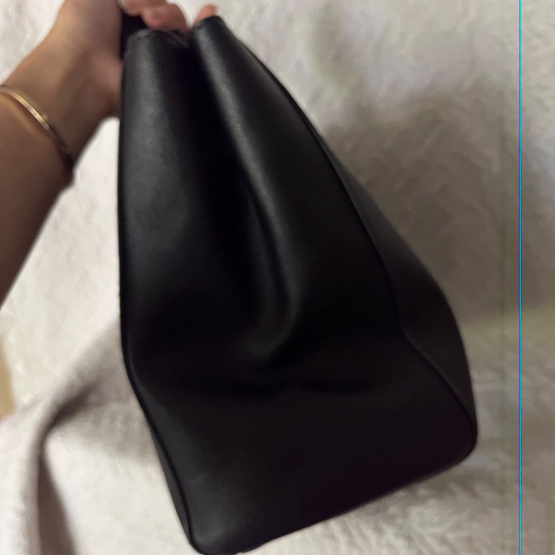 Michael Kors Black Leather Tote Bag (Category: Luxury Bags & Wallets) located in Caloocan City. Submitted by kathkoleksyon (Listing ID 1459888541, Image 3). Description: - Elegant gold hardware details - Comfortable top handles for carrying - Secure zipper closure - Iconic hanging MK charm - Ample interior space for all your essentials - Ideal for everyday use and versatile styling.