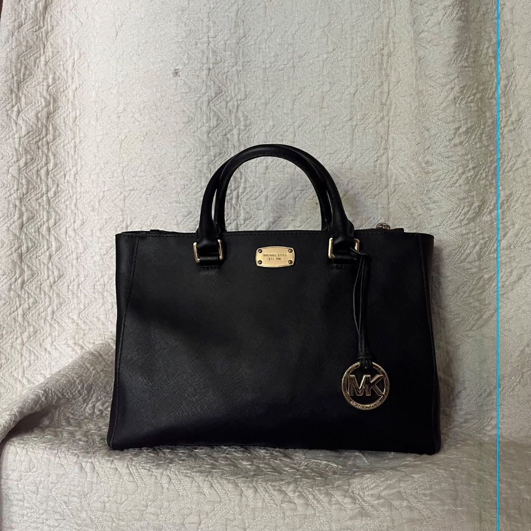 Michael Kors Black Leather Tote Bag (Category: Luxury Bags & Wallets) located in Caloocan City. Submitted by kathkoleksyon (Listing ID 1459888541, Image 1). Description: - Elegant gold hardware details - Comfortable top handles for carrying - Secure zipper closure - Iconic hanging MK charm - Ample interior space for all your essentials - Ideal for everyday use and versatile styling.