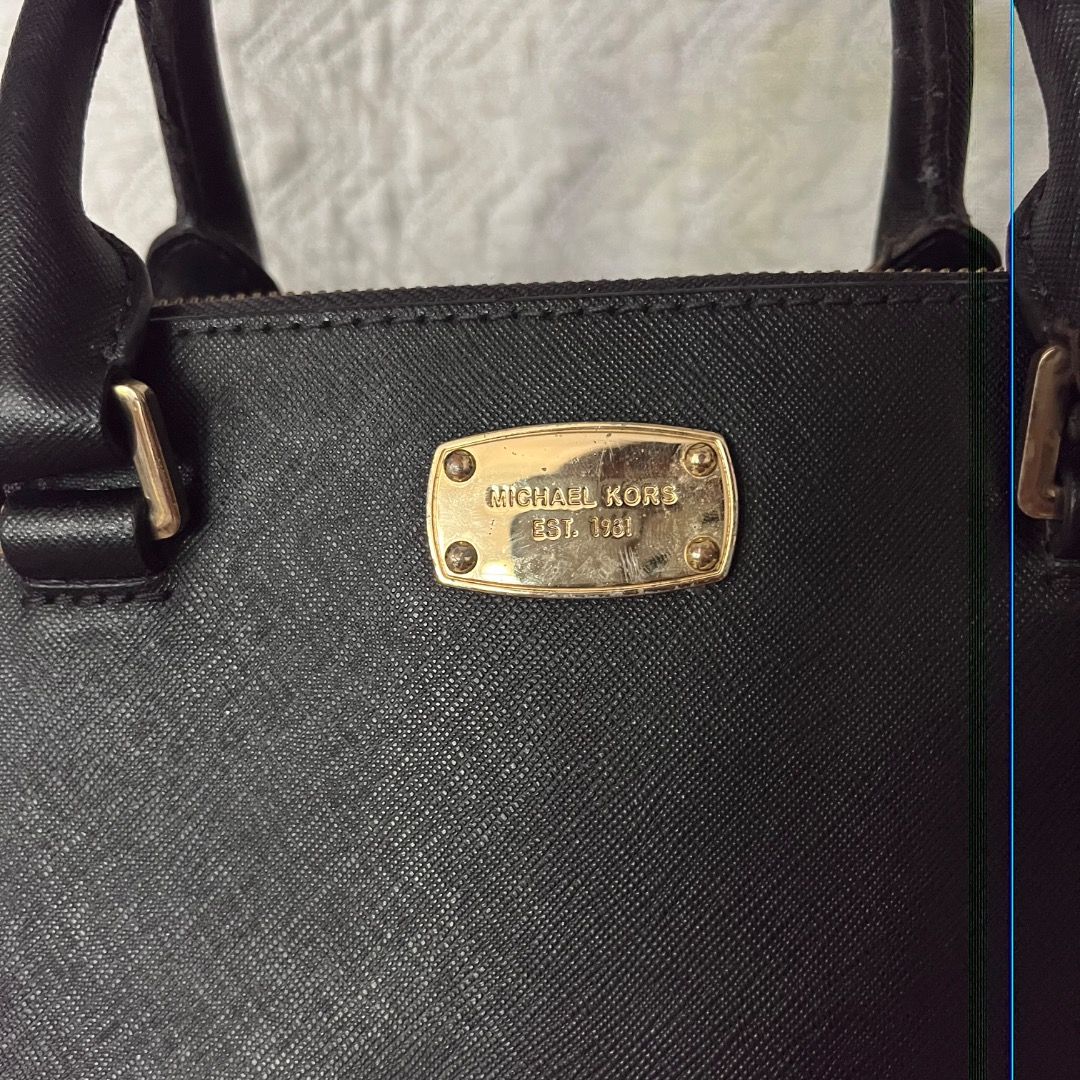 Michael Kors Black Leather Tote Bag (Category: Luxury Bags & Wallets) located in Caloocan City. Submitted by kathkoleksyon (Listing ID 1459888541, Image 2). Description: - Elegant gold hardware details - Comfortable top handles for carrying - Secure zipper closure - Iconic hanging MK charm - Ample interior space for all your essentials - Ideal for everyday use and versatile styling.