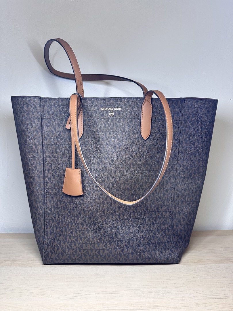 Michael Kors Monogram Tote Bag (Category: Luxury Bags & Wallets) located in Baguio. Submitted by judyannlacaden (Listing ID 1459886540, Image 2). Description: - Classic Michael Kors tote bag - Brown monogram print with tan leather accents - Spacious interior, ideal for everyday use - Prominent logo on the front - Includes a matching leather tag - Comfortable carrying handles.