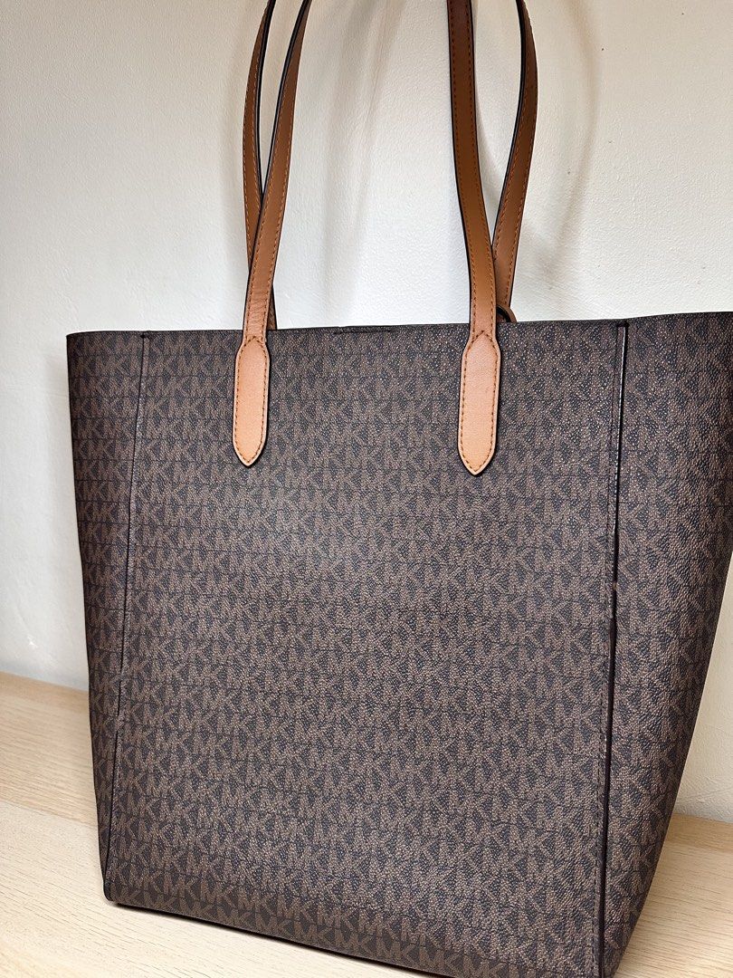 Michael Kors Monogram Tote Bag (Category: Luxury Bags & Wallets) located in Baguio. Submitted by judyannlacaden (Listing ID 1459886540, Image 1). Description: - Classic Michael Kors tote bag - Brown monogram print with tan leather accents - Spacious interior, ideal for everyday use - Prominent logo on the front - Includes a matching leather tag - Comfortable carrying handles.