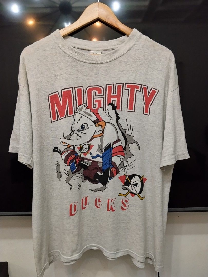 Mighty Ducks Graphic T-Shirt (Category: Tshirts & Polo Shirts ) located in Bulacan. Submitted by waybak90s (Listing ID 1459811362, Image 1). Description: - Grey t-shirt with classic Mighty Ducks graphic - Features the team's mascot in action - Minor flaws: faint yellow stains (especially on sleeves) and a small hole near the graphic - Perfect for fans of the movie or hockey -Dimes:23x27.