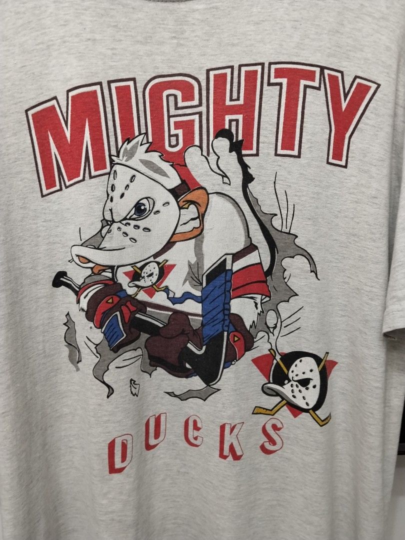 Mighty Ducks Graphic T-Shirt (Category: Tshirts & Polo Shirts ) located in Bulacan. Submitted by waybak90s (Listing ID 1459811362, Image 2). Description: - Grey t-shirt with classic Mighty Ducks graphic - Features the team's mascot in action - Minor flaws: faint yellow stains (especially on sleeves) and a small hole near the graphic - Perfect for fans of the movie or hockey -Dimes:23x27.